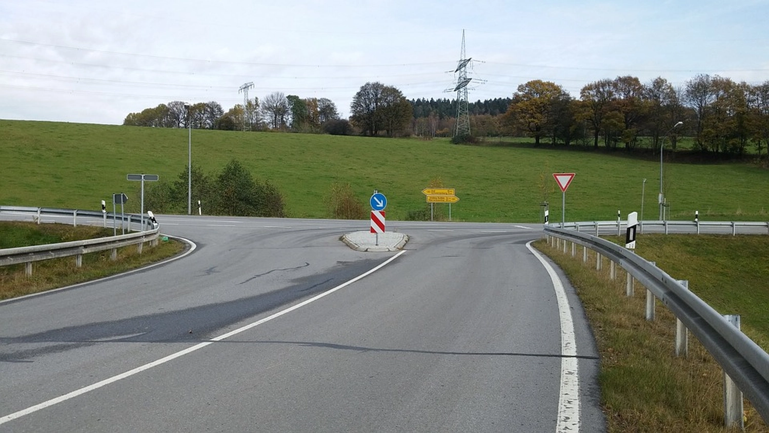 Logos Ingenieurplanungs GmbH – Dieses Bild zeigt eine Straßenkreuzung mit einer Verkehrsinsel in der Mitte, die sich aufgrund der Beschilderung und Infrastruktur wahrscheinlich in Deutschland befindet.